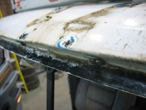 1995 Ford C-350 (Centurion Conversions) - Close-up of a damaged windshield seal showing rust and debris.