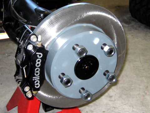 1996 Ford Bronco - Rear axle brake assembly with Wilwood caliper and rotor, mounted on a red jack stand.