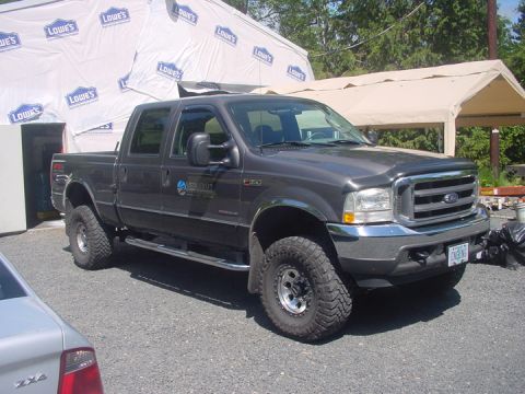 1979 Ford Bronco - A dark gray Ford F-350 pickup truck is parked in front of a construction site.