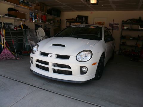 1996 Ford Probe - A white Dodge Neon SRT-4 is parked in a garage, showing its front end and hood scoop.
