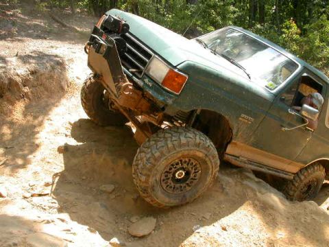 1990 Ford Bronco - This Ford Bronco is navigating a steep, sandy incline on an off-road trail.