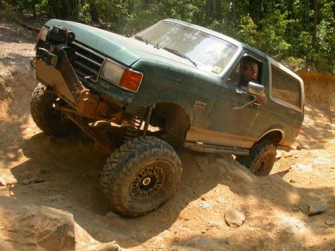 1990 Ford Bronco - This 1990 Ford Bronco navigates a challenging off-road course with steep inclines and rocky terrain.