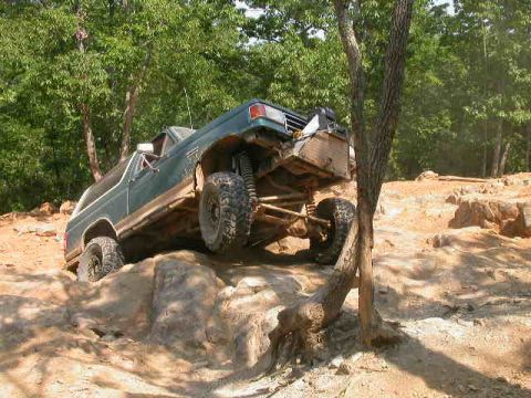 1990 Ford Bronco - A 1990 Ford Bronco navigates a challenging rocky terrain, demonstrating its off-road capabilities.