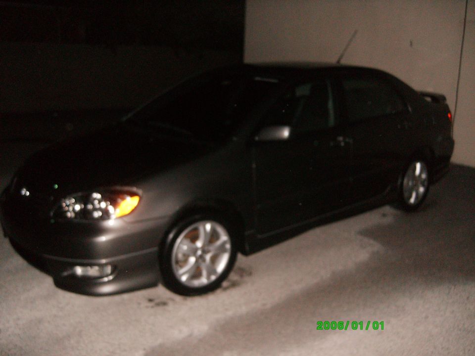 Dark gray Toyota Corolla sedan parked at night under cover