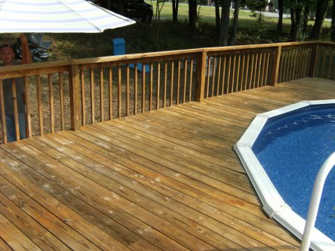 1992 Ford F-150 - A black SUV is partially visible behind a striped umbrella on a wooden deck that overlooks a swimming pool.