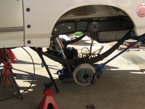 1996 Ford Bronco - Close-up of a vehicle's rear suspension system, showing leaf springs and brake components.