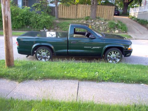 1970 Ford Ranchero - A green Dodge Dakota Sport pickup truck is shown from the side, custom chrome wheels and a tonneau cover.
