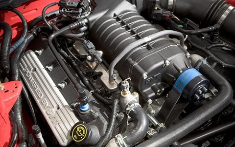 2007 Ford Mustang - The engine bay features a supercharger and "POWERED BY SVT" branding on the valve cover.