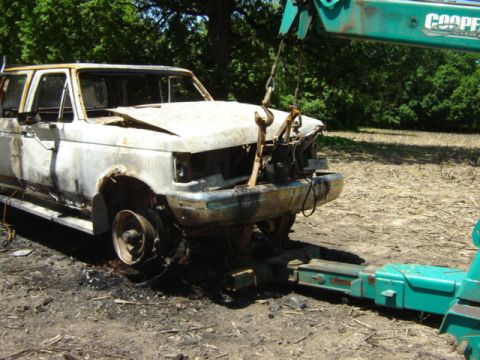 1992 Ford Bronco - A severely damaged 1992 Ford F-350 truck is being towed after a fire.