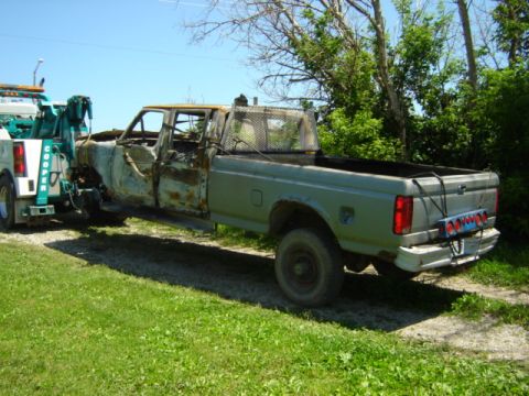 1992 Ford Bronco - Wrecked Ford F-350 pickup truck being towed by a tow truck.