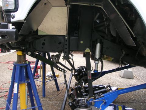 1996 Ford Bronco - Custom suspension and chassis modifications are visible on a vehicle supported by jack stands.