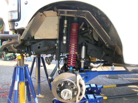 1996 Ford Bronco - The vehicle's front suspension and frame are exposed, showing custom modifications and heavy-duty components.