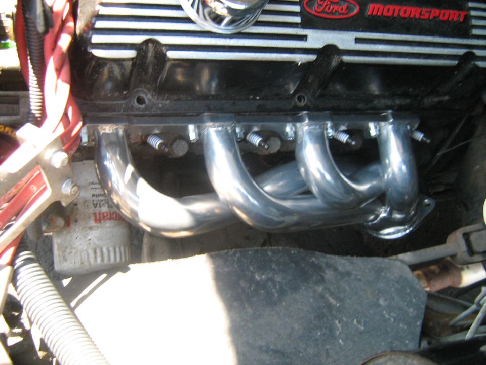 Polished tubular exhaust headers on a Ford engine with Ford Motorsport valve cover
