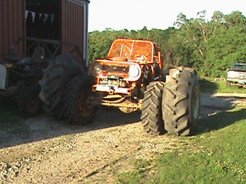 1973 Ford Bronco - This heavily modified vehicle features oversized tires and a protective roll cage, suggesting it's built for off-road challenges.