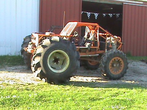 1973 Ford Bronco - Custom buggy with oversized tires sits outside a red barn.