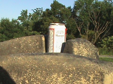 1973 Ford Bronco - A can of Budweiser rests on rough, textured rocks under a clear sky.