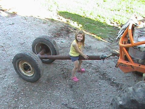1973 Ford Bronco - A young girl poses with a trailer axle assembly.
