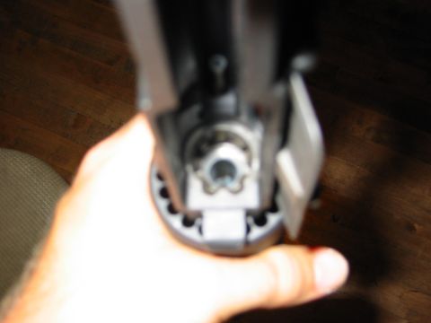 1996 Ford Bronco - A hand holds a mechanical part, possibly from a vehicle, against a wooden floor background.