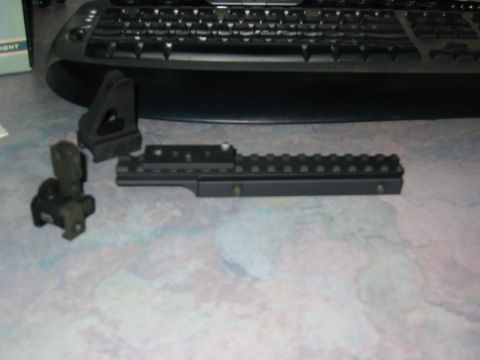 1996 Ford Bronco - Two gun sight parts are laid out on a desk next to a computer keyboard.