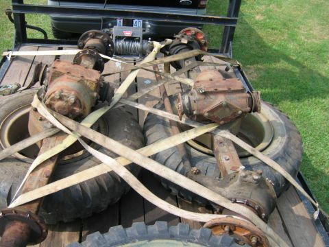 1992 Ford Mustang - Differential axles and tires are strapped to a trailer, with a winch in the background.