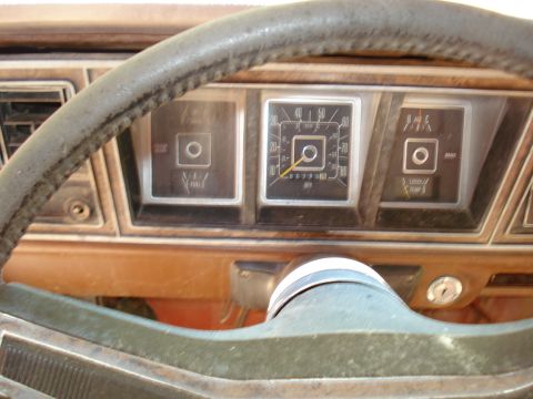 1989 Ford Bronco - A close-up view of the dashboard and steering wheel of an older vehicle, showing the speedometer, fuel gauge, and temperature gauge.