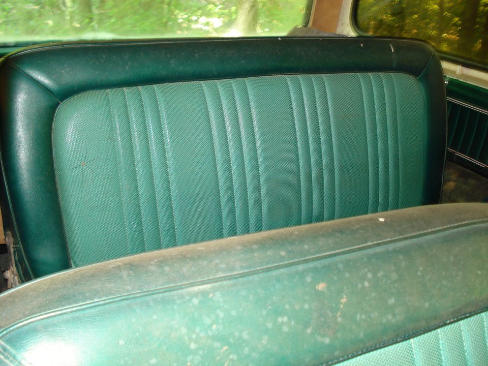 Green vinyl bench seat in a vintage vehicle.