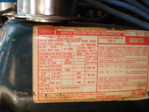 1989 Ford Bronco - A close-up view of a Ford Motor Company vehicle emissions control information sticker on a blue engine component. The sticker details engin…