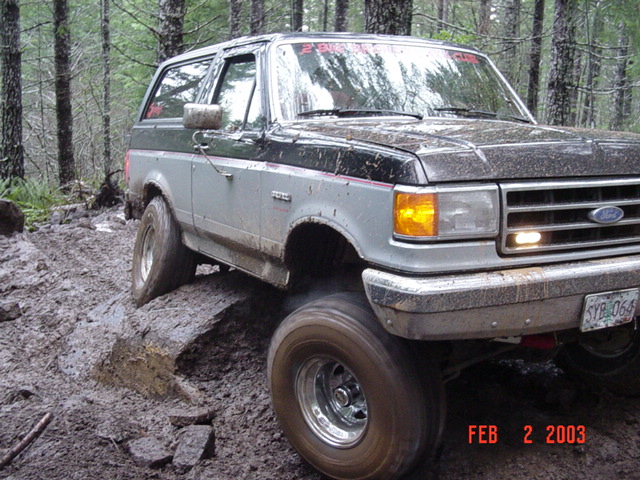 Ford Bronco on a muddy trail in the woods
