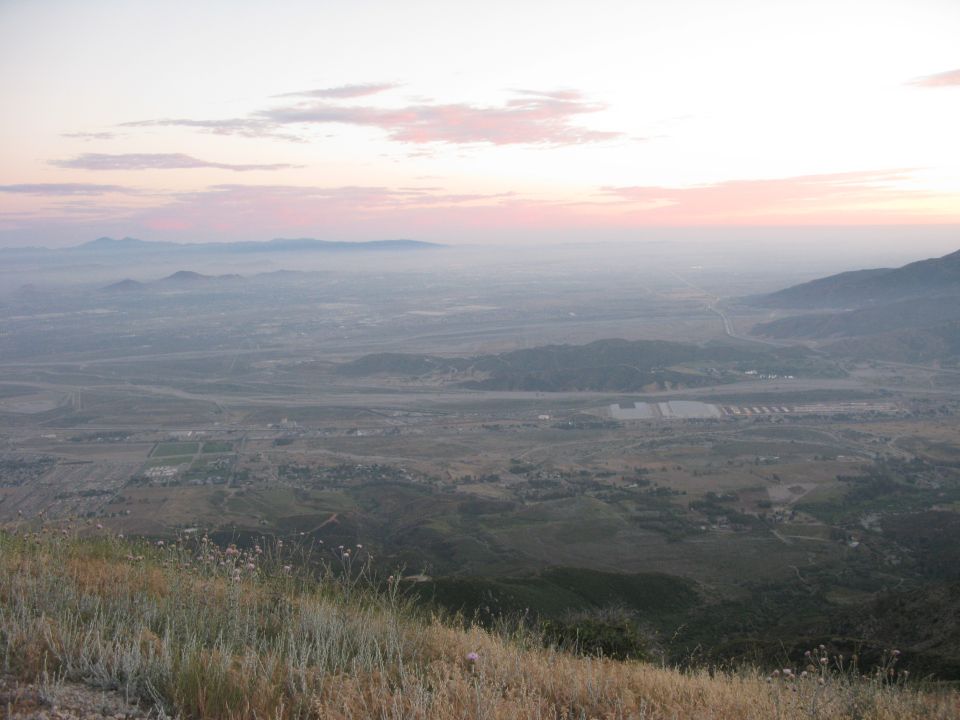 Hazy valley landscape at dawn viewed from a grassy hillside