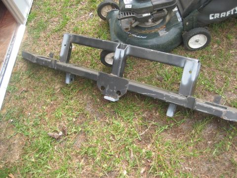 1981 Ford Bronco - Back side of a fabricated black steel rear bumper laid on the grass, showing the welded box-tube crossmember, mounting brackets, receiver h…