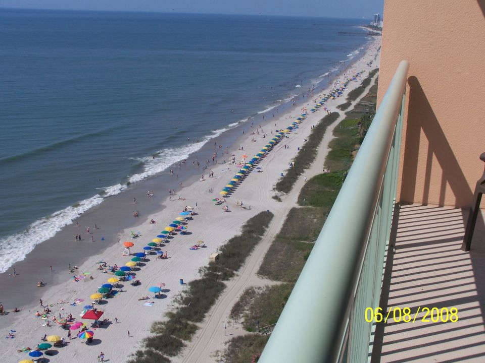 Aerial balcony view of a beach with umbrellas and ocean