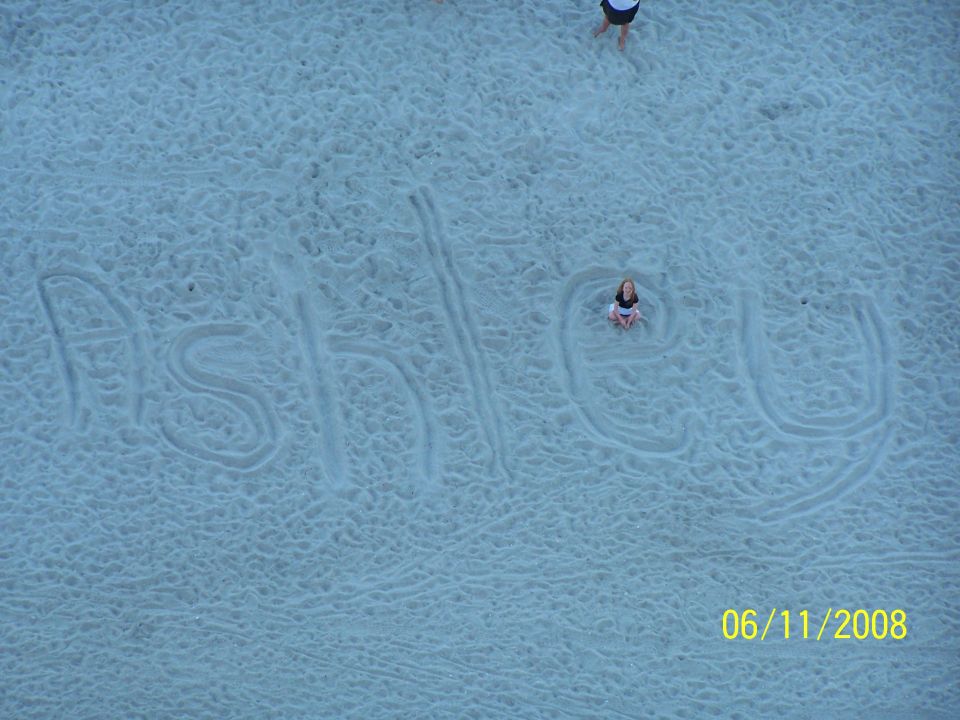 Aerial photo of the name 'Ashley' written large in beach sand
