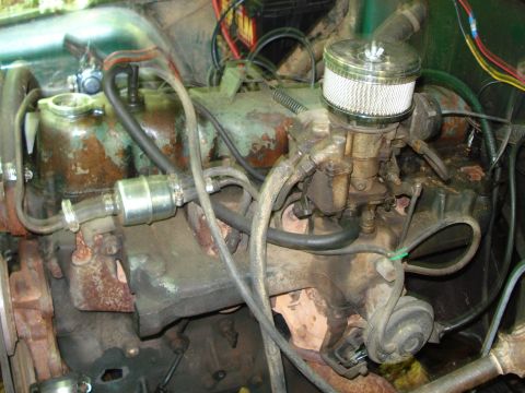1989 Ford Bronco - A close-up view of a dirty and rusty V8 engine, likely from an older truck or SUV, featuring a carburetor with an air filter and various ho…