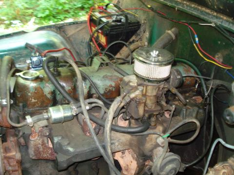1989 Ford Bronco - A close-up view of the engine bay of a classic vehicle, showing the carburetor, air filter, fuel filter, and battery. The engine components…