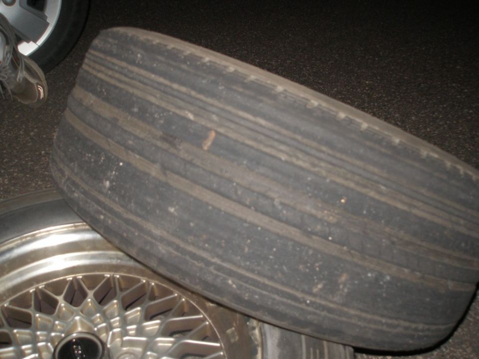 Worn-out tire on a silver multi-spoke wheel
