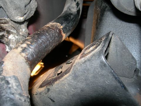 1992 Ford Taurus - A close-up view shows a heavily corroded metal pipe, possibly part of an exhaust or suspension system, with visible rust and black residue.…