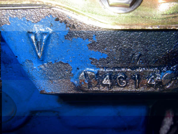 Engine block with blue paint peeling off, showing casting numbers '174614' and a 'V' symbol