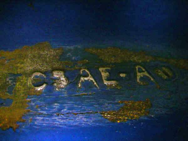 Close-up of stamped metal with letters C3AE-AD visible