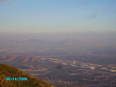 1990 Ford Bronco - A vast, hazy cityscape stretches out towards distant mountains under a clear sky.