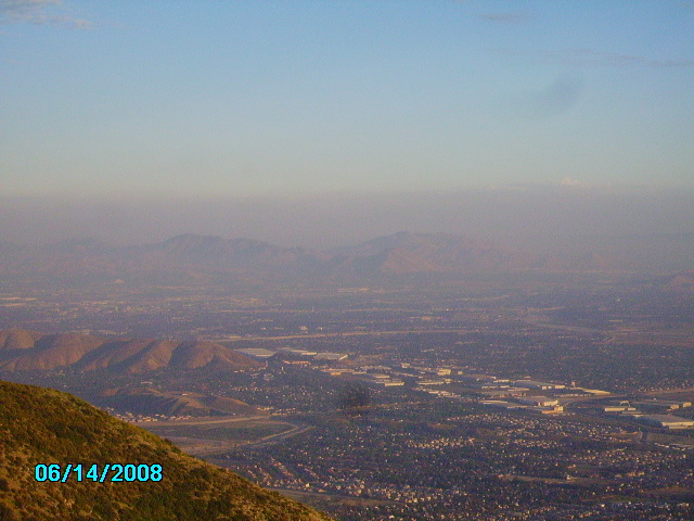 Overhead view of a hazy city with mountains in the distance. Date stamp reads 06/14/2008