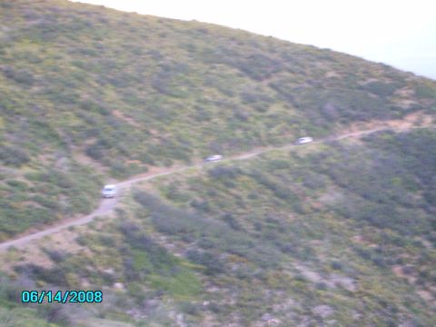 1990 Ford Bronco - Multiple vehicles travel a dirt road on a hillside, captured on 06/14/2008.