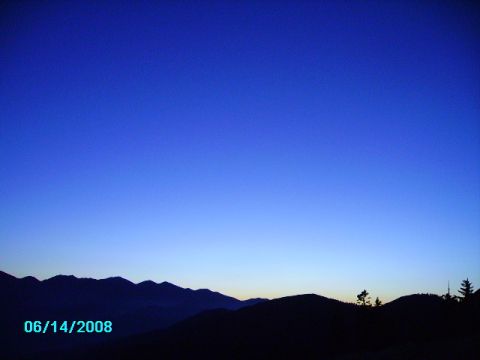 1990 Ford Bronco - A twilight scene with mountains silhouetted against a deep blue sky, marked with a date and website.