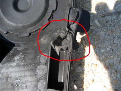 1993 Ford Probe - A damaged gray plastic automotive part is shown in a close-up view, with a red circle indicating the area of damage.