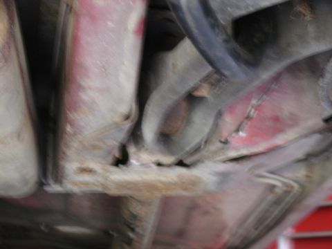 1988 Ford Bronco - Close-up view of heavily rusted vehicle frame and suspension parts.