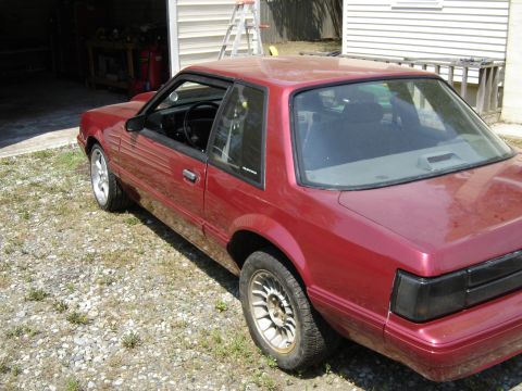 1988 Ford Bronco - This 1988 Ford Mustang coupe is shown from a 3/4 front angle, parked outdoors near a garage.