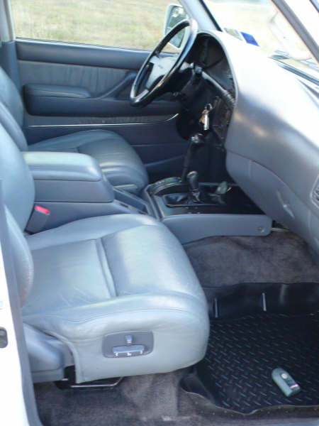 1986 Ford Bronco - The interior of a Toyota Land Cruiser from the 1990s, gray leather seats and a dashboard.