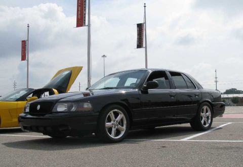 2003 Mercury Marauder - A black 2003 Mercury Marauder is seen at a car show, parked next to a yellow sports car with its hood open.