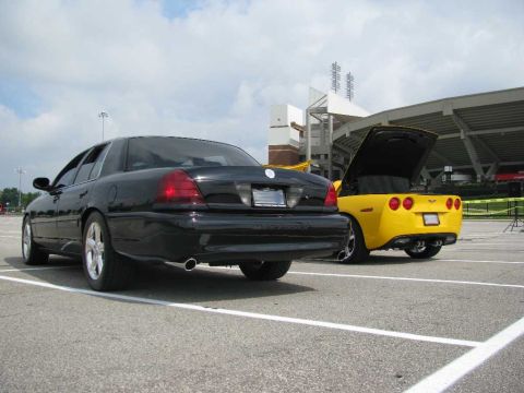 2003 Mercury Marauder - Two cars, a black Mercury Marauder and a yellow Chevrolet Corvette, are parked in a lot.
