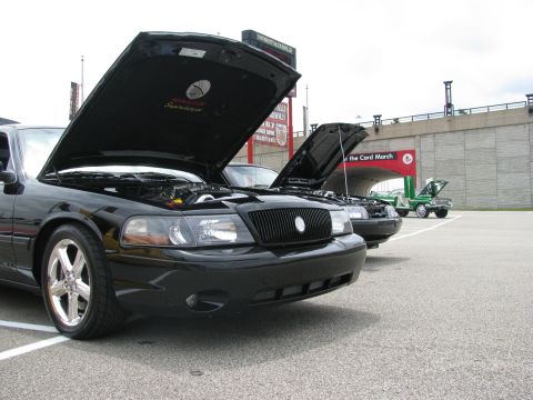 2003 Mercury Marauder - Two black Mercury Marauders and a green tow truck are parked with hoods open at an outdoor event.