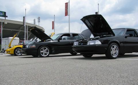 2003 Mercury Marauder - A black 1993 Ford Mustang GT is displayed with its hood open, alongside other vehicles at an outdoor event.